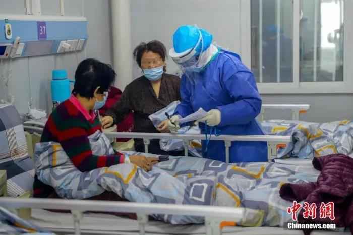 资料图:武汉火神山医院感染二科一病区的隔离病房内护士长胡晶为患者进行身体检查。中新社记者 张畅 摄 天使,节日快乐!