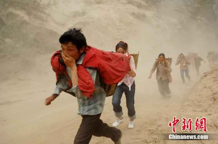 2008年5月20日,汶川震区民众快速通过山体滑坡险段。中新社记者 陈文 摄 汶川地震十二年:遥忆悲伤,记住灾难中不屈的精神